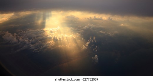 Rays of light shining through dark warm clouds on another cloud layer for background - Shutterstock ID 627732089