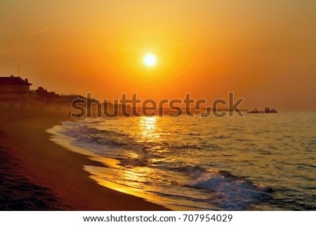 The rays of the rising sun over the Mediterranean Sea with a muddy background in Malgrat de Mar, Spain.