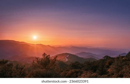 The rays of the setting sun illuminate the mountains and the trail leading through them. Cyprus, Madari.