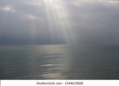 
the rays of the sun break through the clouds at sea