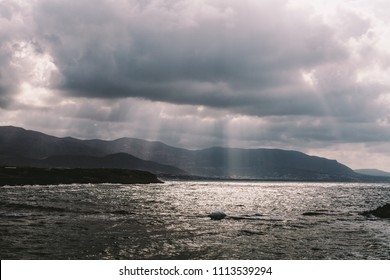 The rays of the sun are looking through the clouds to the sea