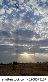 The rays of the sun making their way through the clouds against the background of the radio tower