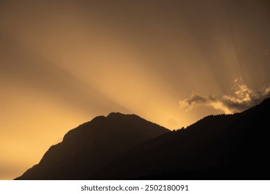 Rays of sun shining behind the mountains. Golden hour - Powered by Shutterstock