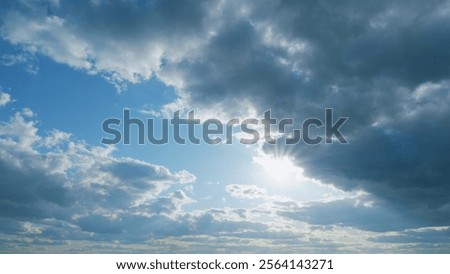 Rays of sun through clouds. Blue sky with cloudscape backlit bright sunlight through summer. Timelapse.