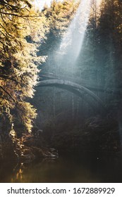 Rays Of Sunlight Cast Across The Wooden Bridge At Moulton Falls In Battle Ground, Washington, USA.