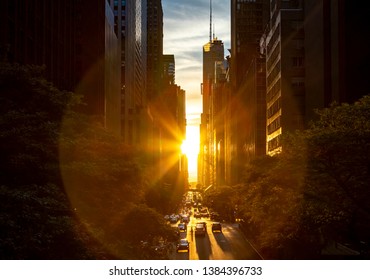 Rays of sunlight shining between the skyline buildings along 42nd Street in Midtown Manhattan, New York City NYC