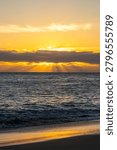 Rays of sunlight shining down on the Pacific Ocean as the last bit of 