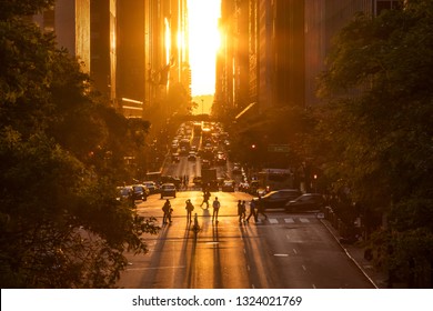 Rays of sunlight shining down on the people and traffic at the intersections along 42nd Street through Midtown Manhattan in New York City