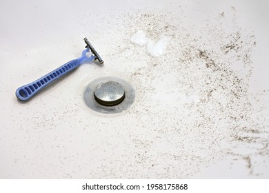 Razor With Shaved Face Hair In A Bathroom Sink.