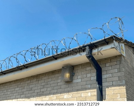 Razor wire on the roof of a building to prevent vandalism and theft. No people.