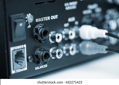Rca cables on back panel of dj mixer, closeup. Blue tone