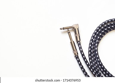 RCT, UK / April 15th 2020 : Coiled guitar audio cable with right-angle jack plug on one end.