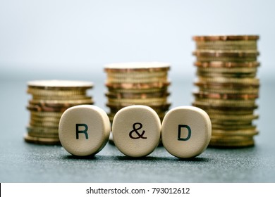 R&D letter block and stack coins, business concept. R&D stands for Research & Development.