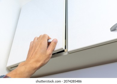 Reach Out And Open The High Cabinet Door