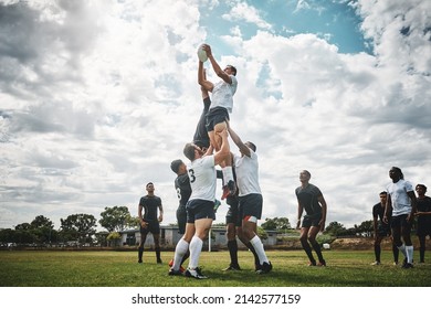 Reach for the sky. Shot of two rugby teams competing over a ball during a line out of a rugby match outside on a filed.
