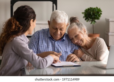 Reaching an agreement. Happy old spouses visiting lawyer broker realtor to buy real estate sign insurance policy create will. Excited aged married couple clients sign financial deal with bank manager
