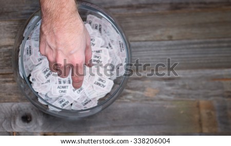 Reaching into a bowl of raffle tickets to find a winner