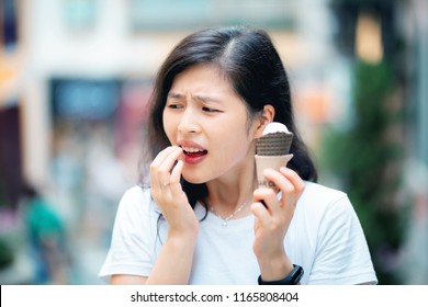 Reaction Of Young Woman With Sensitive Teeth Eating Icecream