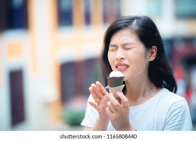 Reaction Of Young Woman With Sensitive Teeth Eating Icecream