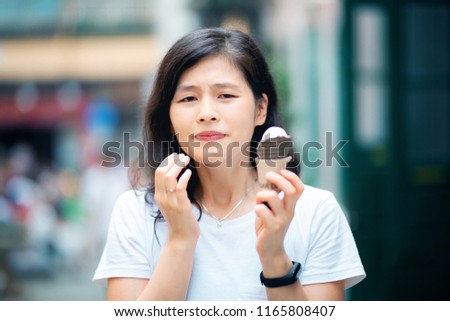 Reaction of young woman with sensitive teeth eating icecream