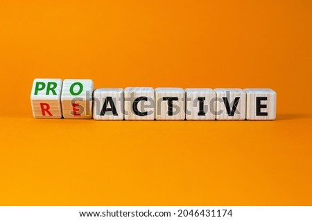 Reactive or proactive symbol. Turned wooden cubes and changed the word reactive to proactive. Business and reactive or proactive concept. Beautiful orange background, copy space.