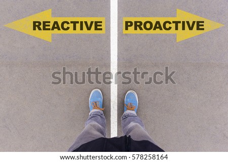 Reactive vs Proactive text on yellow arrows on asphalt ground, feet and shoes on floor, personal perspective footsie concept