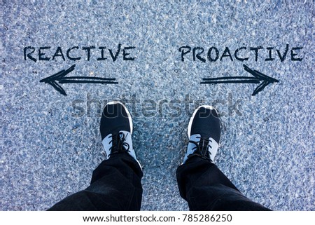 Reactive vs Proactive text on asphalt ground