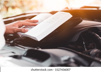 Read the car maintenance manual,Engine maintenance, car care concept. - Shutterstock ID 1527436007