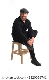 readhead man sitting on stool and looking at camra on white background