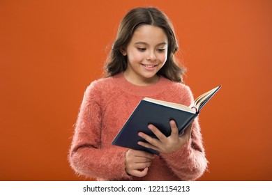 Reading Activities For Kids. Girl Hold Book Read Story Over Orange Background. Child Enjoy Reading Book. Book Store Concept. Wonderful Free Childrens Books Available To Read. Childrens Literature.