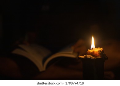 Reading A Book In The Dark By Candlelight