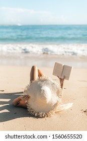 reading a book on a sandy beach in Hawaii