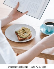 reading a book while having breakfast