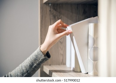 Reading concept. Vintage tone of  woman selecting book from a bookshelf. Portrait of serious girl in library looking for a book - Powered by Shutterstock