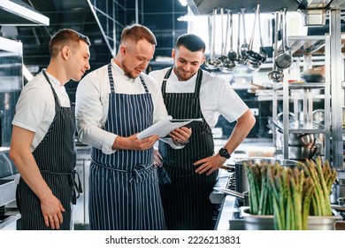 Reading the documents. Kitchen workers is together preparing the food. - Powered by Shutterstock