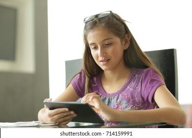 READING AND DOING HOMEWORK, Teenager Doing Homework At Home, And With Ipad, State-of-the-art Technology At The Forefront