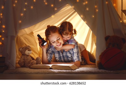 reading and family games in children's tent. mother and child daughter with  book and flashlight before going to bed
 - Powered by Shutterstock