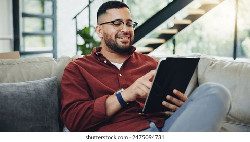 Reading, glasses and happy man relax with tablet on sofa for social media, streaming and newsletter info at home. Digital, ebook and male person with app for subscription, research or service sign up