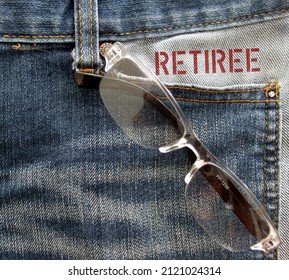 Reading Glasses In Jeans Pocket With Text Inscription RETIREE, Refer To Person Who Has Retired From Employment Or Stop Working In Regular Paid Full Time Job Because Of Their Age