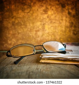 Reading Glasses And Newspaper On Wooden Table, Vintage Style.