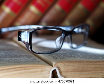 reading glasses on old open book, closeup, shallow depth of field