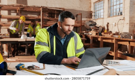Reading, laptop and man in workshop for construction contract, material supplier and carpentry. Contractor, research and person on computer with inventory, timber stock or planning for infrastructure