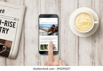 Reading News Article On The Phone During Coffee Time. Newspapers, Coffee On The Wooden Table With Top View.