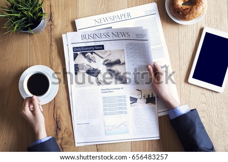 Reading newspaper on desk