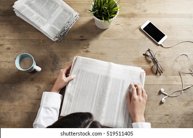 Reading Newspaper On Wooden Table