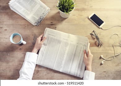 Reading Newspaper On Wooden Table