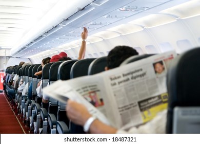 Reading Newspaper In A Plane