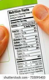 Reading Nutrition Facts On Protein Jar. Close-up.