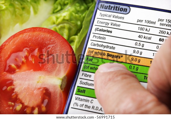 Reading a nutrition label on food packaging\
with fresh salad\
background