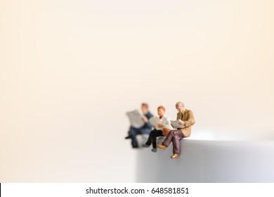 Reading, relaxing, hobby concept. Close up of group miniature mini figures man and woman sit and read a book and a newspaper on the cup of hot coffee. - Powered by Shutterstock